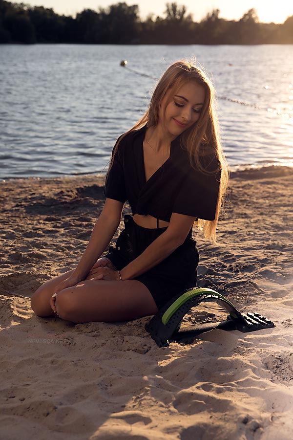 Model Svenja is sitting in front of a lake.